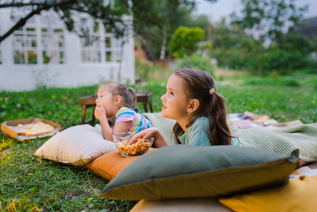 Girls eating popcorn while laying on pillows