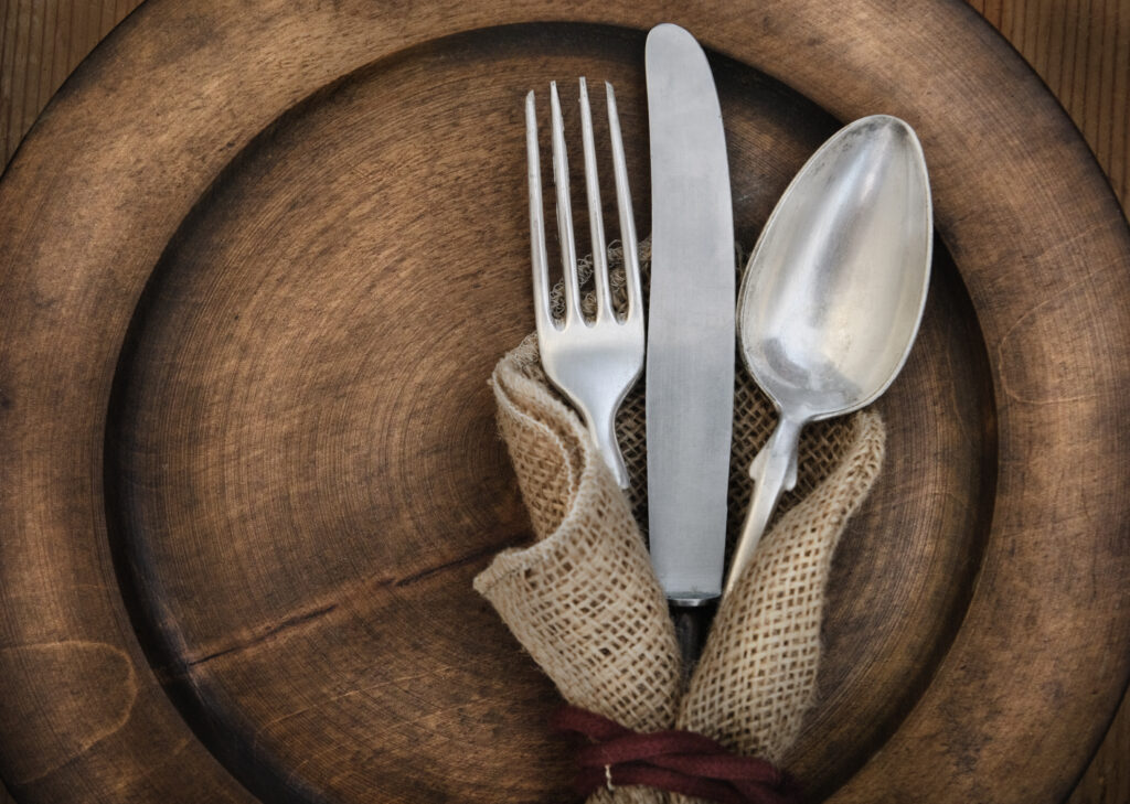 Vintage silverware on rustic wooden plate