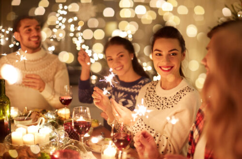 winter holidays and people concept - happy friends with sparklers celebrating
