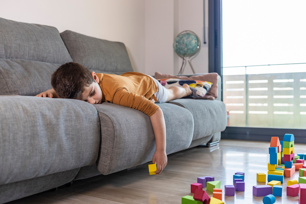 Bored child playing with blocks at home