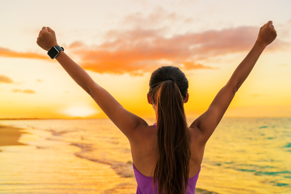 Woman celebrating at sunset