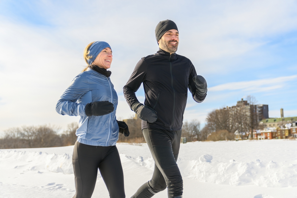 couple in the winter running together in nature