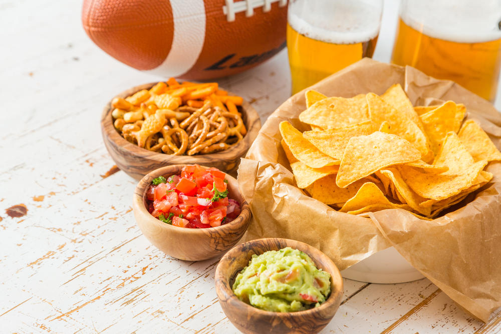 Football party food, super bowl day, nachos salsa guacamole on wood background