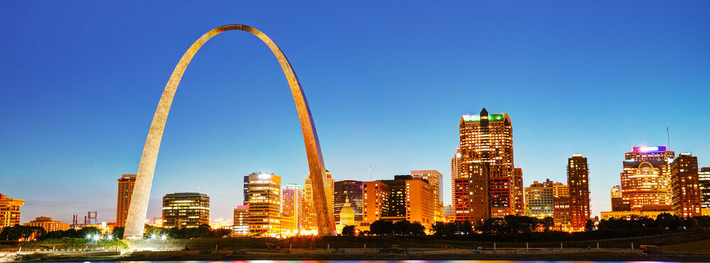 Downtown St Louis, MO with the Old Courthouse and the Gateway Arch at sunset