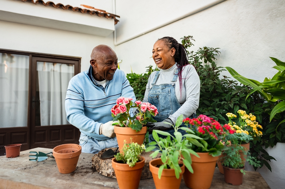 Happy African American senior people gardening together at home