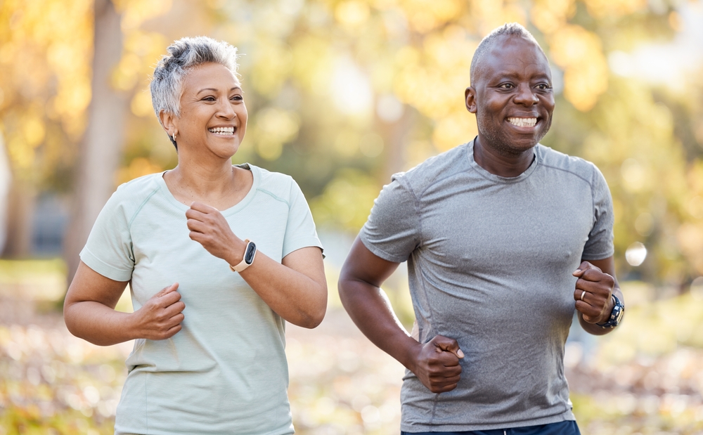 Health, smile and running with old couple in park for fitness, workout and exercise. Wellness, retirement and happy with senior black man and woman training in nature for motivation, sports or cardio