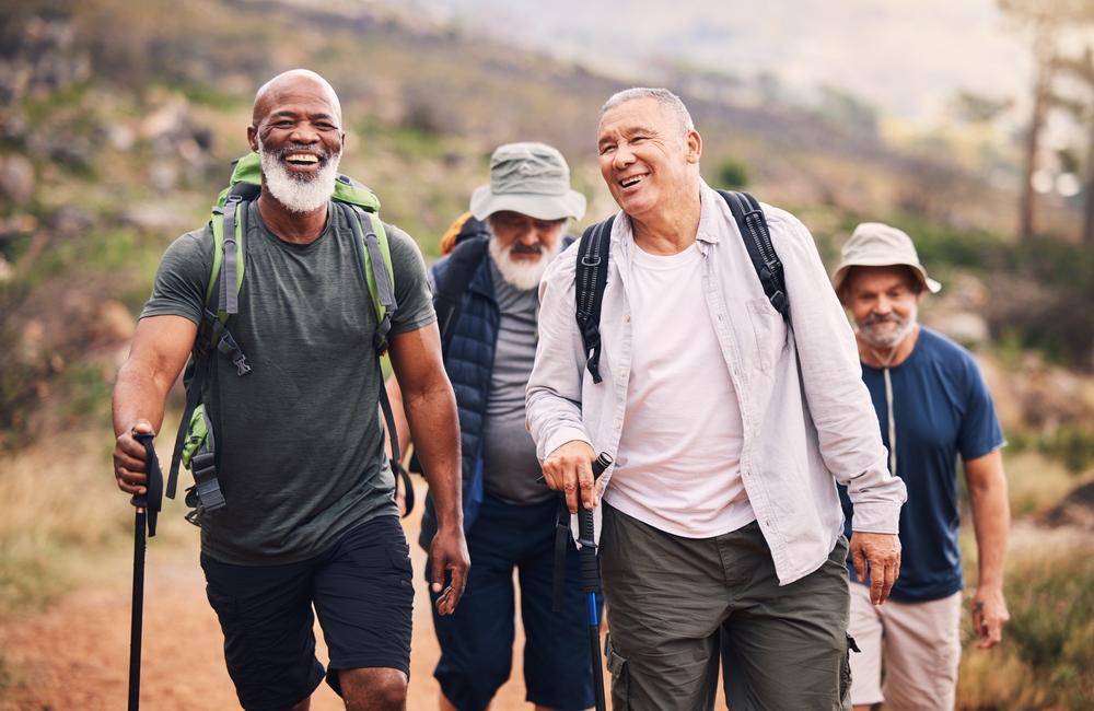 Hiking, smile and group of old men on mountain for fitness, trekking and backpacking adventure. Explorer, discovery and expedition with senior friends walking for health, retirement and journey