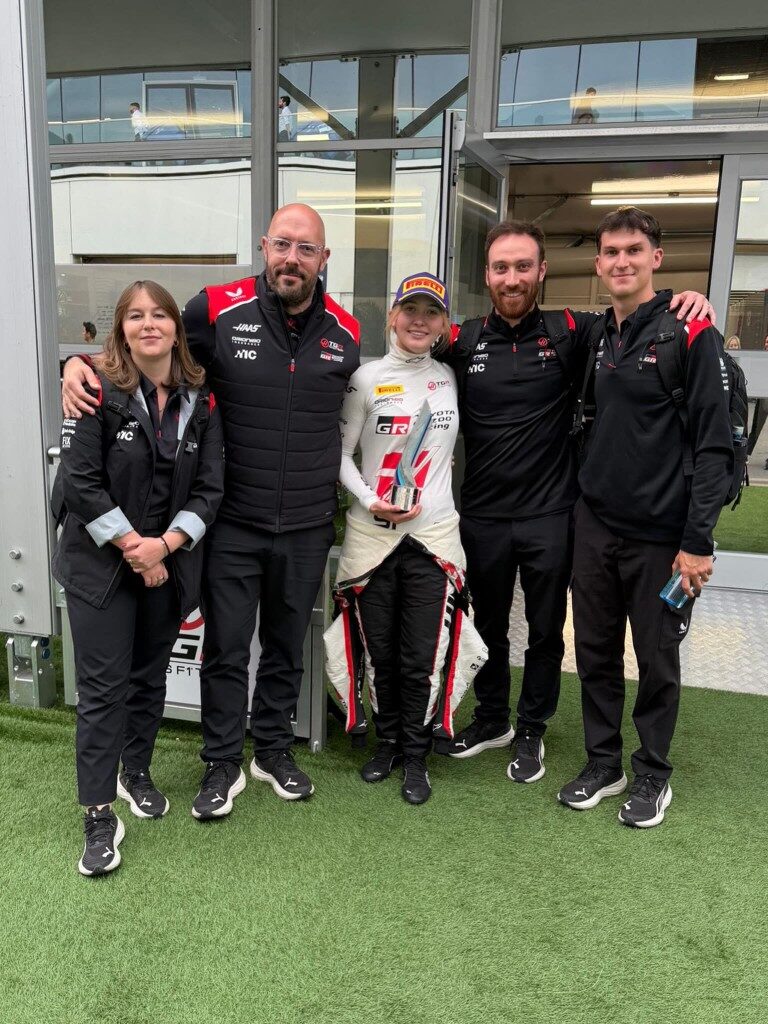 Kaylee Countryman celebrating with Toyota Gazoo Racing and Haas F1 team holding trophy